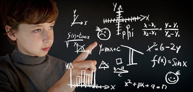 Quadro negro cheio de fórmulas matemáticas complexas, equações de álgebra e geometria desenhadas com giz branco.